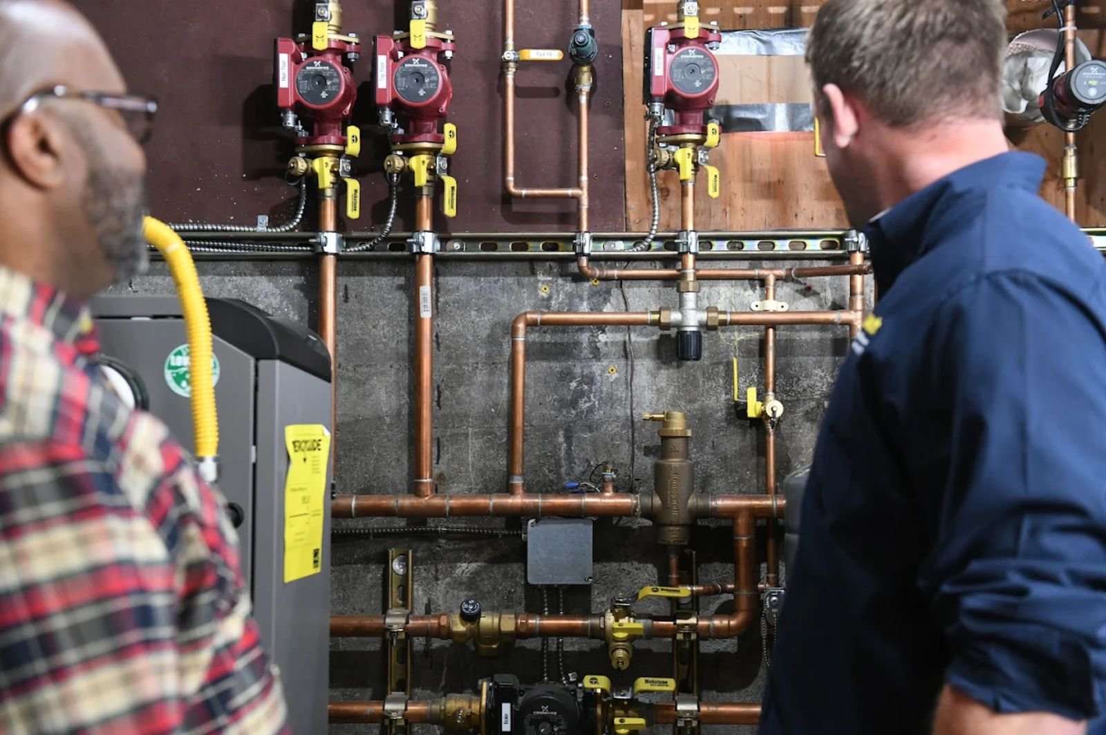 A Plumber Kings technician walking a Newmarket homeowner through newly installed boiler piping