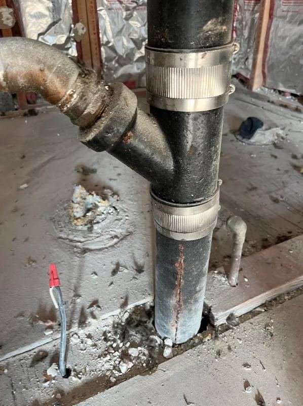 Cast iron soil stack repaired with stainless no-hub couplings
